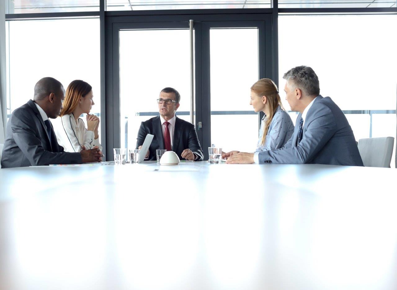 Ein Chef spricht mit vier Mitarbeitern